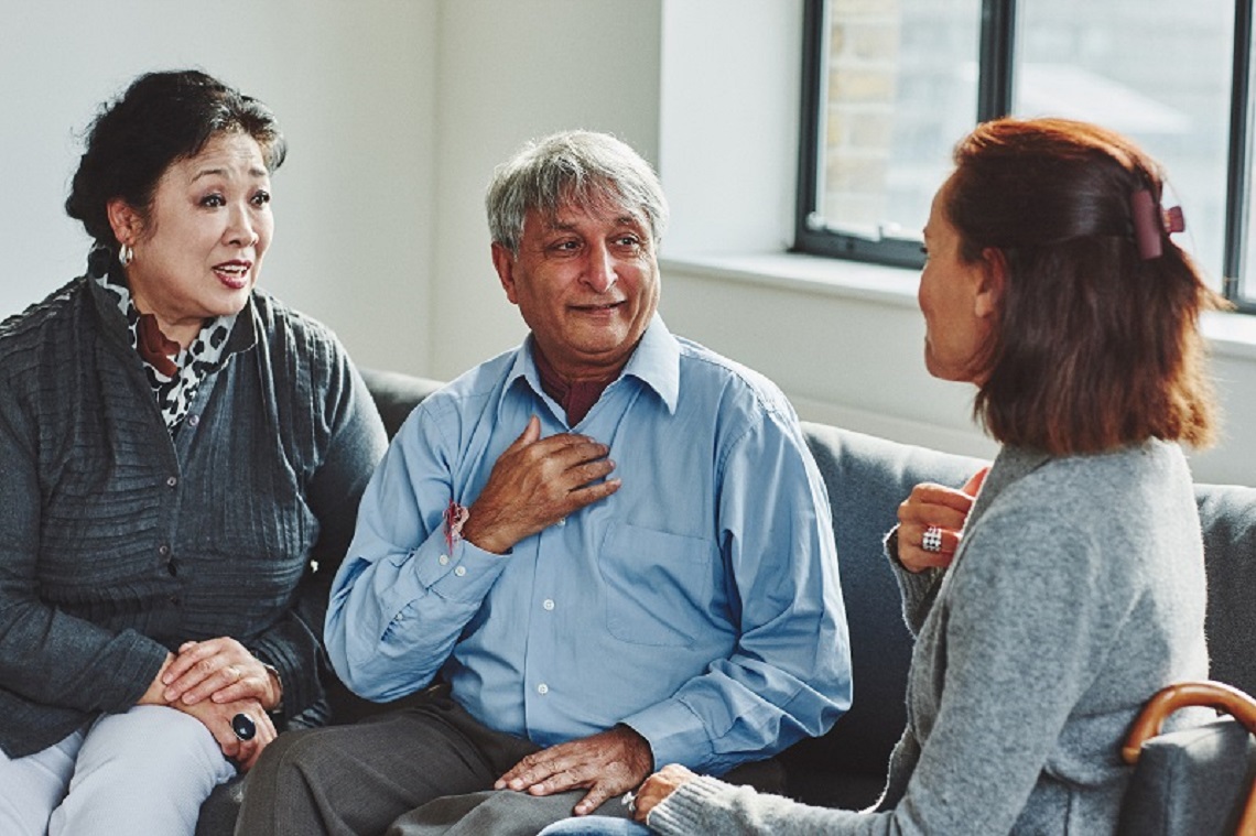 Three people on sofa talking