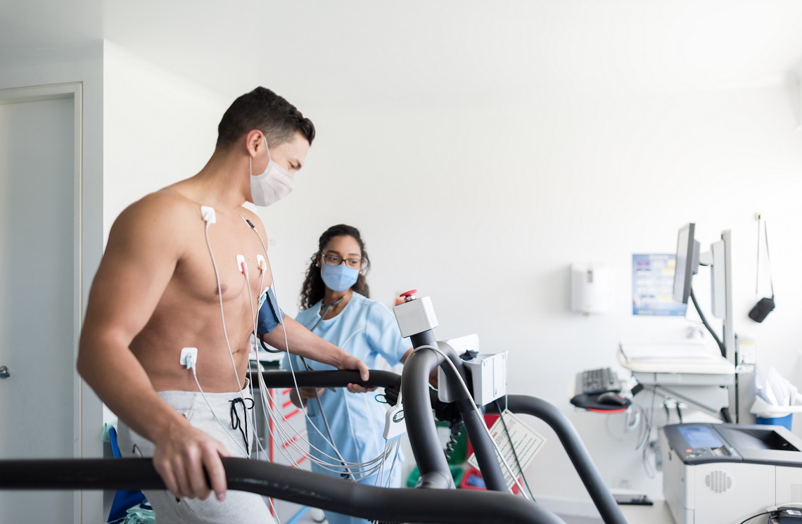 Young man on treadmill being monitored