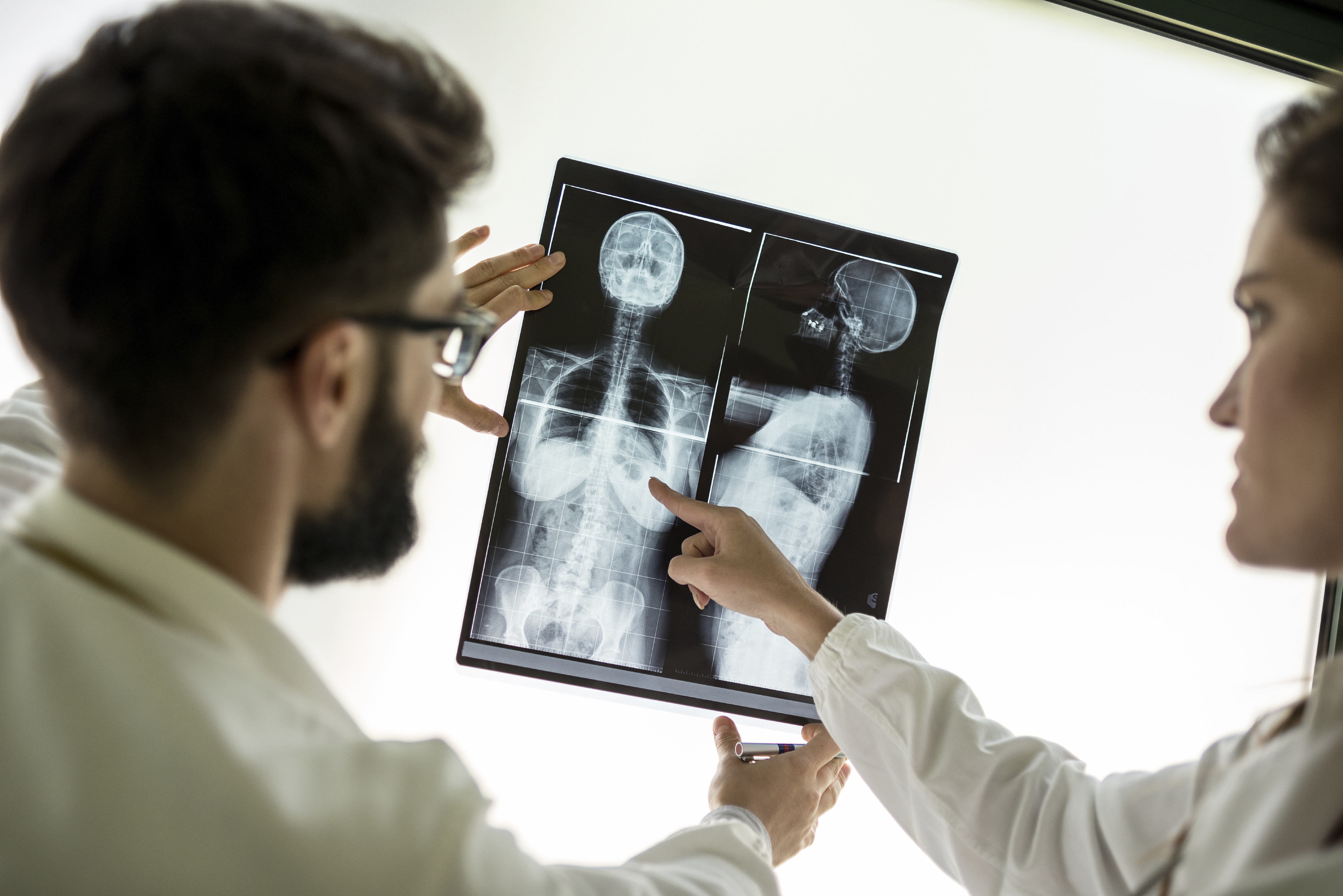 Two clinicians looking at an xray of breast cancer